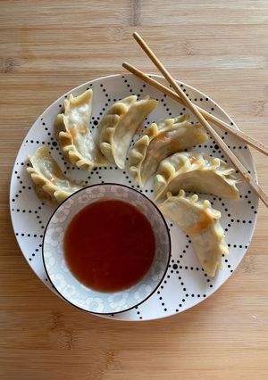 A picture of Chinese Dumplings 🥟🥕 with Sweet and Sour Sauce 🍜.