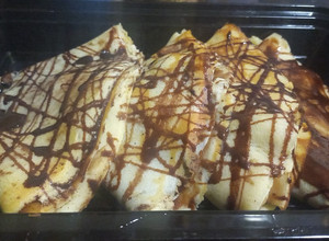 A picture of Banana crepe with chocolate syrup.