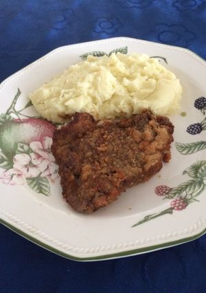 Una foto de Pollo apanado con puré