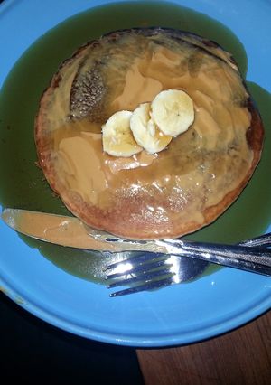 A picture of pancakes with banana and peanut butter.