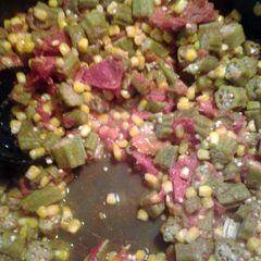 A picture of corn okra and tomatoes.