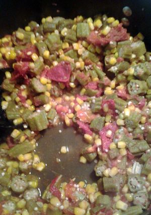 A picture of corn okra and tomatoes.