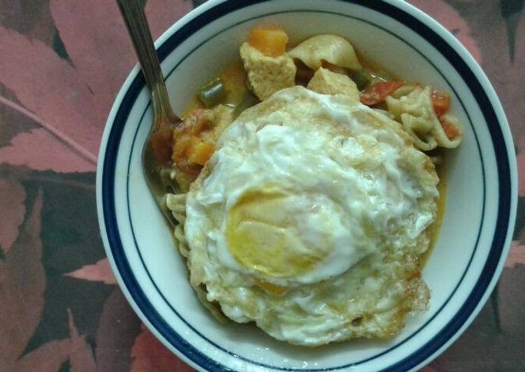 Tofu and mushroom soupy mixed pasta served with fried eggs.