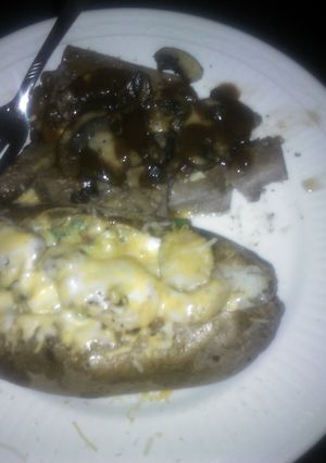 A picture of Steak with mushrooms. Shrimp stuffed baked potato.