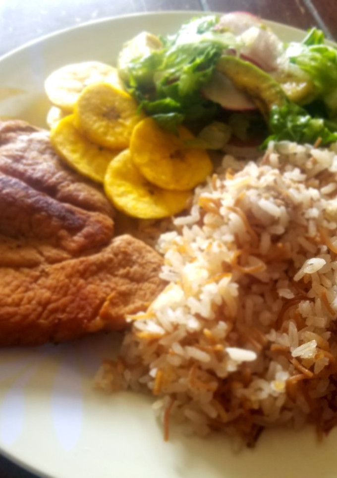 Una foto de Cerdo asado con arroz de fideos, ensalada y tajadas de plátano