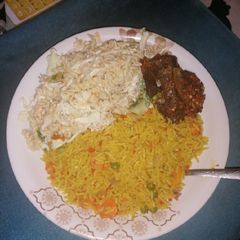 A picture of Turmeric Jollof Rice with chicken wings.