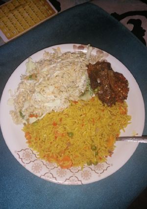 A picture of Turmeric Jollof Rice with chicken wings.