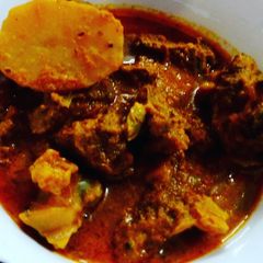 A picture of Bengali goat meat curry with potato.
