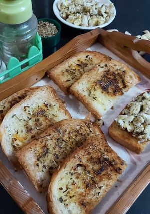 A picture of Garlic Bread with scrambled eggs.