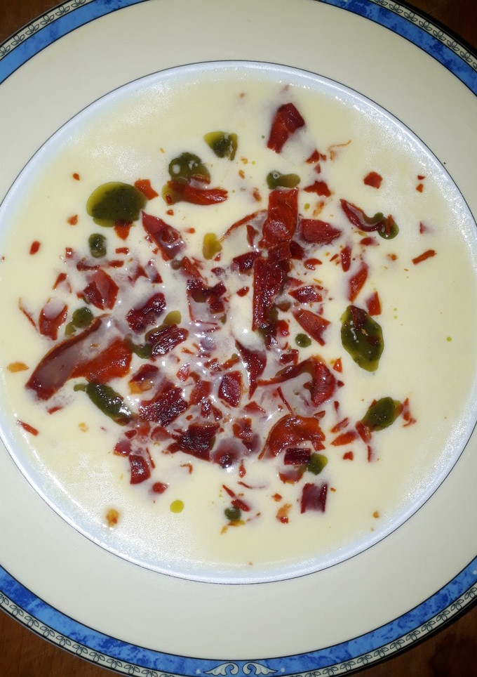 Una foto de Sopa de melón, con aceite de albahaca, y crujiente de jamón