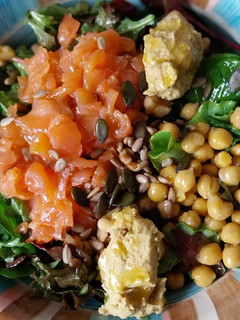 Una foto de Ensalada con salmón ahumado, garbanzos, hummus y pipas con vinagreta de miel y mostaza