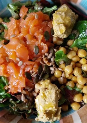 Una foto de Ensalada con salmón ahumado, garbanzos, hummus y pipas con vinagreta de miel y mostaza