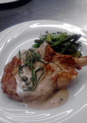 A picture of seared veal chop with creamy caper burr Blanc and wild rice pilaf.