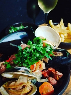 Una foto de Estofado de mariscos con papas fritas y salsa verde