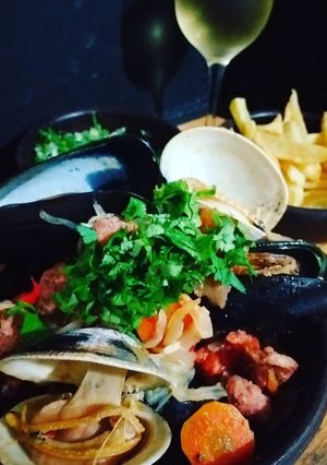 Una foto de Estofado de mariscos con papas fritas y salsa verde