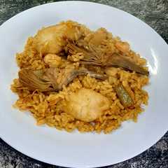 Una foto de Arroz con huevas de sepia, gambas, alcachofas y ajetes