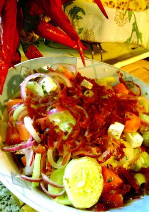A picture of feta and prosciutto salad with mint topping.