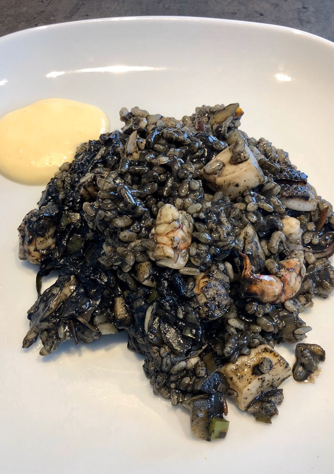 Una foto de Arroz negro con sepia y gambones