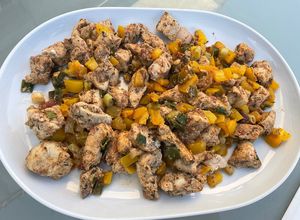 Une photo de Poulet à la tomate, poivron jaune et cébettes