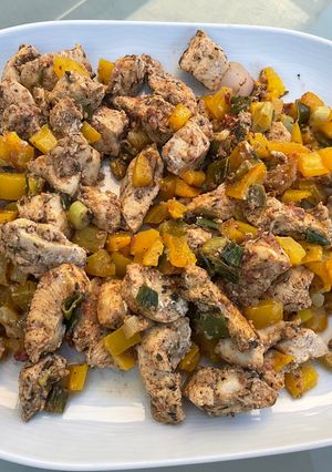 Une photo de Poulet à la tomate, poivron jaune et cebettes