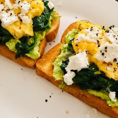 A picture of Avo toast with spinach, scrambled eggs and feta.