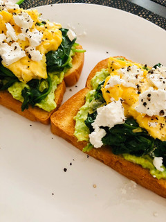 A picture of Avo toast with spinach, scrambled eggs and feta.