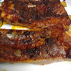 A picture of Ribs in an oven.
