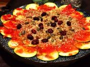 Una foto de carpaccio de calabacín con tomate