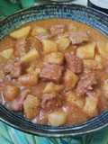Patatas con carne en salsa con picada de frutos secos