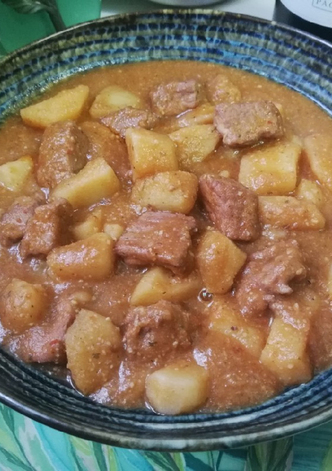 Una foto de Patatas con carne en salsa con picada de frutos secos