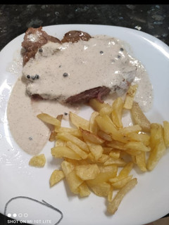 Una foto de Entrecot con salsa a la pimienta y patatas fritas