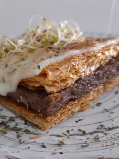 Una foto de Milhojas gratinado de carrilleras al vino