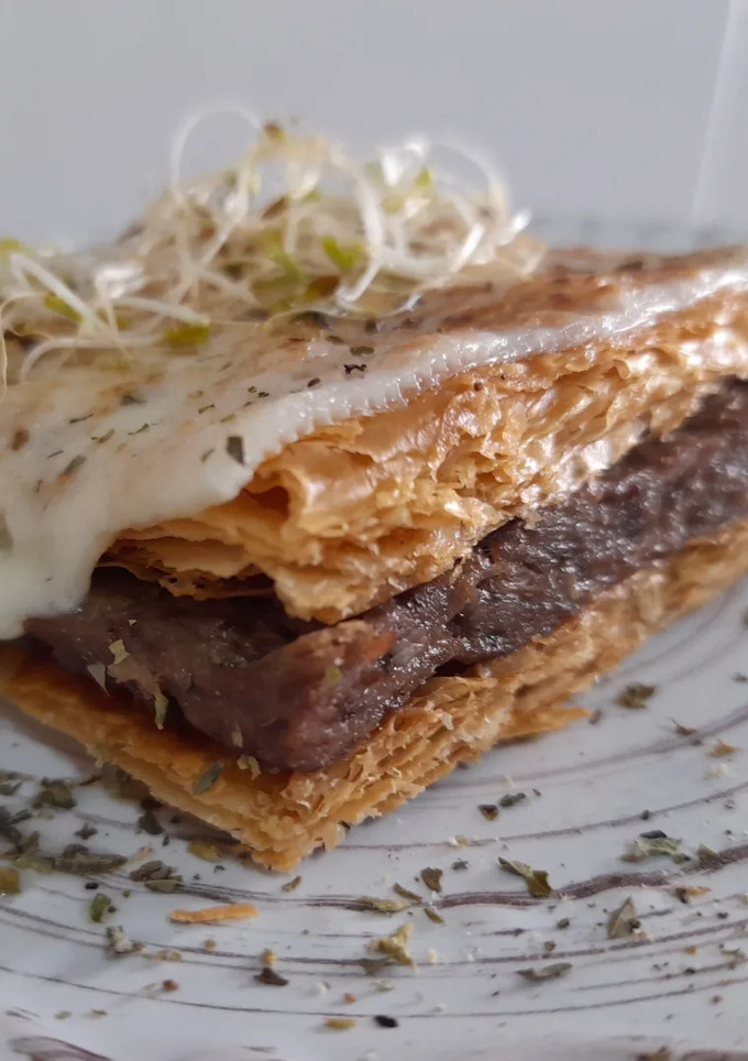 Una foto de Milhojas gratinado de carrilleras al vino