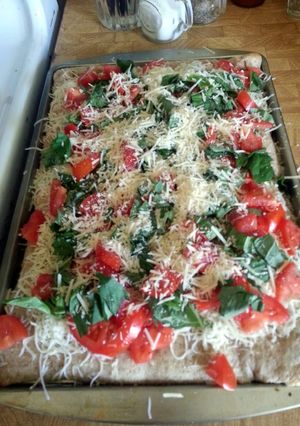 A picture of olive oil tomato basil pizza.