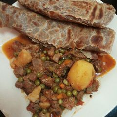 A picture of Beef peas stew with brown chapati.