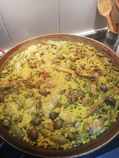 Una foto de Paella con caracoles y verdura