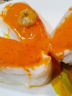 Una foto de Centros de merluza congelados al vapor con salsa de pimientos