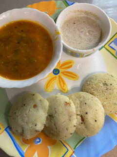 A picture of Idli sambar with coconut chutney.