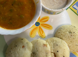 A picture of Idli sambar with coconut chutney.