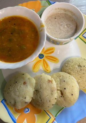 A picture of Idli sambar with coconut chutney.