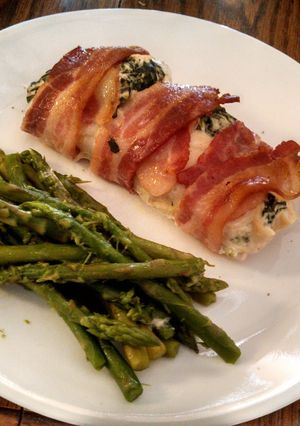 A picture of creamy spinach, bacon wrapped chicken breasts.