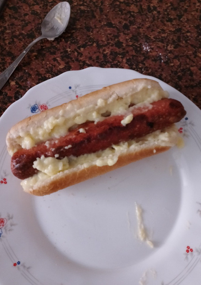Una foto de Hot dog con salsa de queso