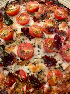 Una foto de Pizza de rúcula y cherry con base de brócoli