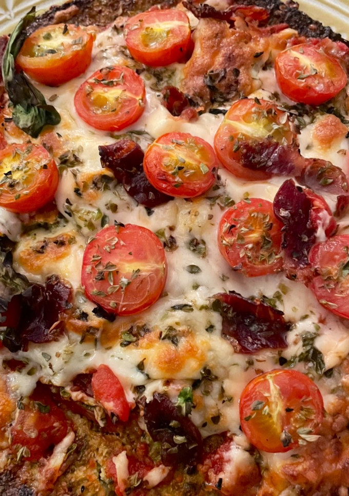 Una foto de Pizza de rúcula y cherry con base de brócoli
