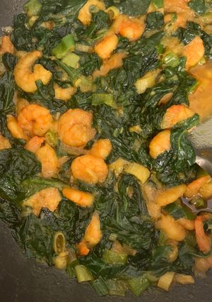 A picture of King prawns curry with spinach.