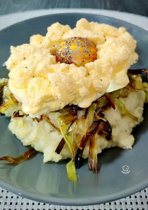 Una foto de Parmentier trufado de patata y parmesano con crujiente de puerro y huevo nube