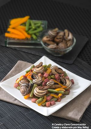 Una foto de Wok de caracoles con verdura y jamón