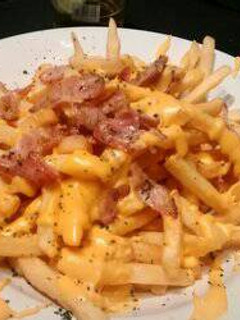 Una foto de Papas fritas, cheddar y panceta