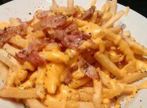 Una foto de Papas fritas, cheddar y panceta
