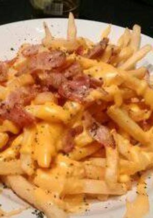 Una foto de Papas fritas, cheddar y panceta